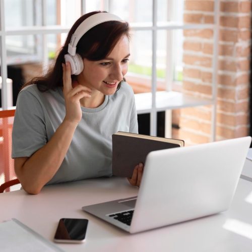 Mujer en videoconferencia con auriculares